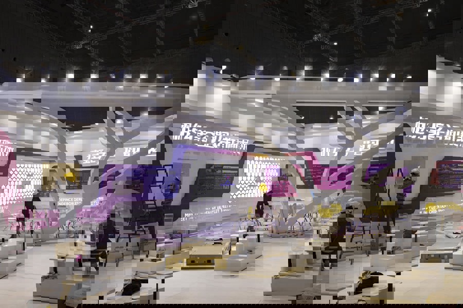 参展商将卡通形象的kt板放置在展台前.