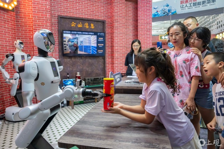 在2025世界人工智能大会WAIC里2025弄主题街区,丰富的服务落地场景、复古里弄+智能未来“结合的反差感吸引了大批观众。多才多艺的机器人们为顾客提供便利商品、炸爆米花、串关东煮,还会敲鼓、扭秧歌。