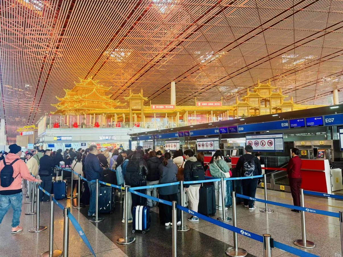 旅客在首都机场值机柜台办理乘机手续。人民网记者 