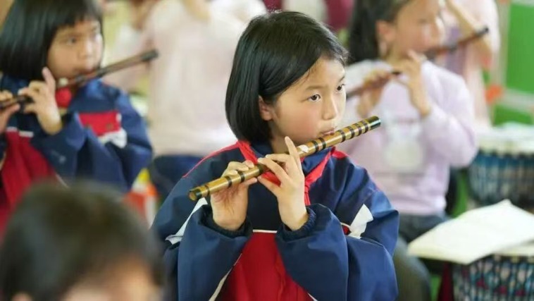 图为蓓娜练习吹竹笛。受访者供图