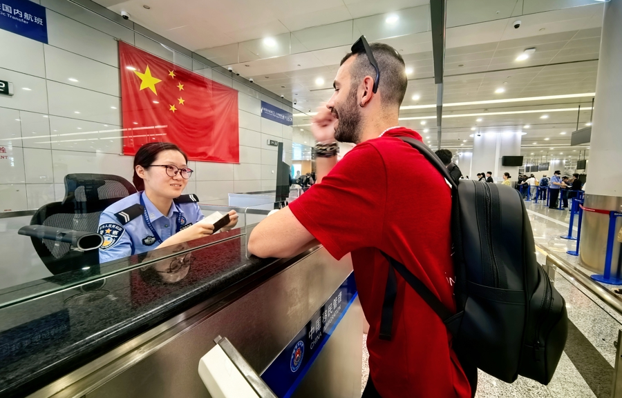 浦东国际机场口岸,移民管理警察为旅客办理边检查验手续。魏文亨