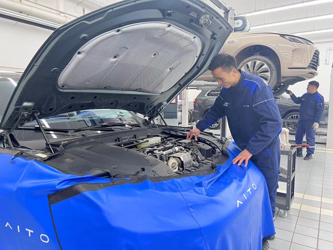 张甲震在为新能源汽车做保养。人民网记者 