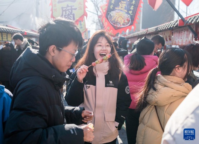 在北京沙河大集，一名女孩在品尝特色小吃。新华社记者 