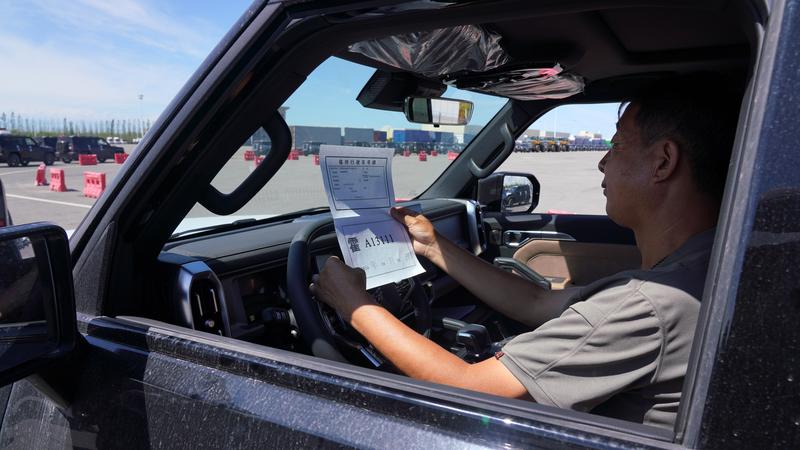 在新疆霍尔果斯公路口岸，驾驶员在检查车辆出口手续。新华社资料