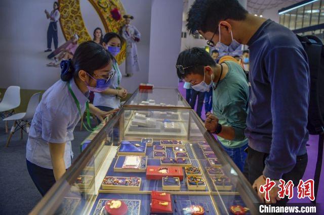 资料图:民众在2022世界珠宝发展大会的菜百展台上选购古法金饰品。 资料图:民众在2022世界珠宝发展大会的菜百展台上选购古法金饰品。